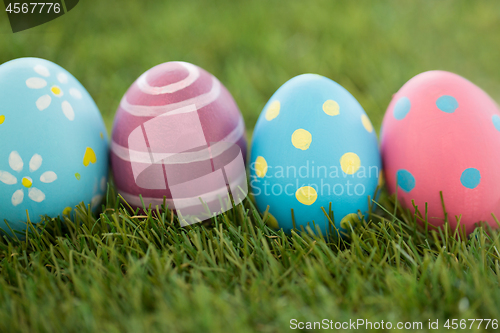 Image of row of colored easter eggs on artificial grass