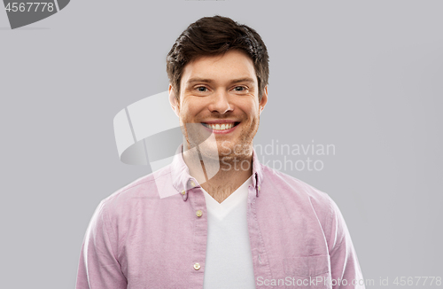 Image of smiling young man over grey background