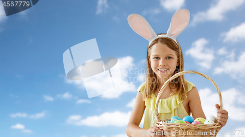 Image of happy girl with colored easter eggs over blue sky