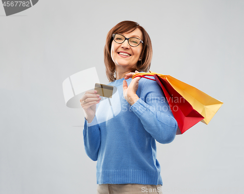 Image of senior woman with shopping bags and credit card