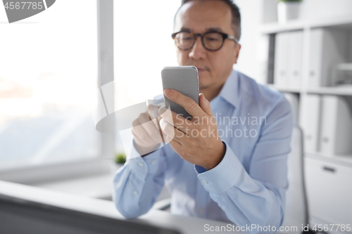 Image of businessman using smartphone at office