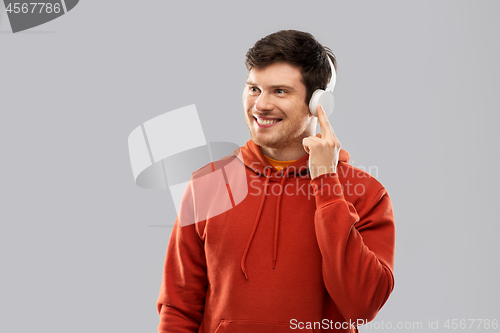 Image of happy young man in headphones and red hoodie