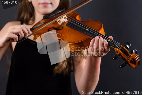 Image of Close up of professional violin in hands of little violinist playing it