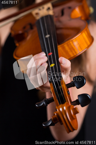 Image of Close up of professional violin in hands of little violinist playing it