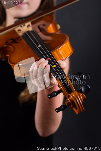 Image of Close up of professional violin in hands of little violinist playing it