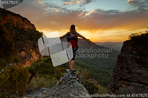 Image of Hiker standing firm on narrow ledge  in wilderness mountains