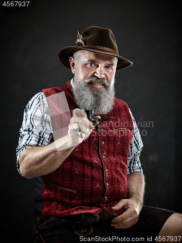 Image of dramatic portrait of senior smoking tobacco pipe