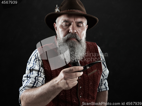 Image of dramatic portrait of senior smoking tobacco pipe