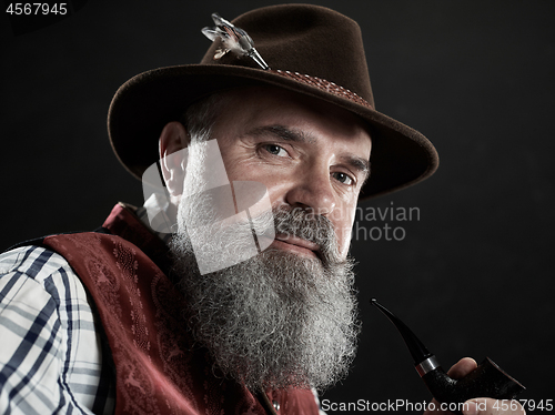 Image of dramatic portrait of senior smoking tobacco pipe