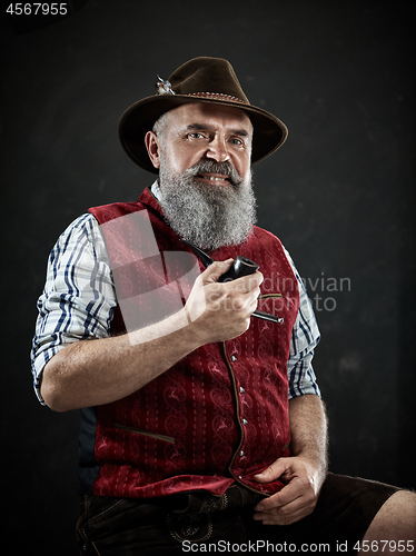 Image of dramatic portrait of senior smoking tobacco pipe