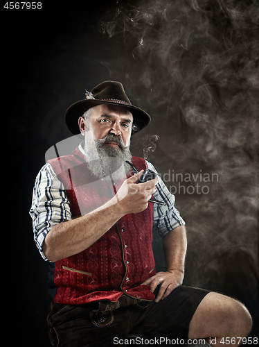 Image of dramatic portrait of senior smoking tobacco pipe