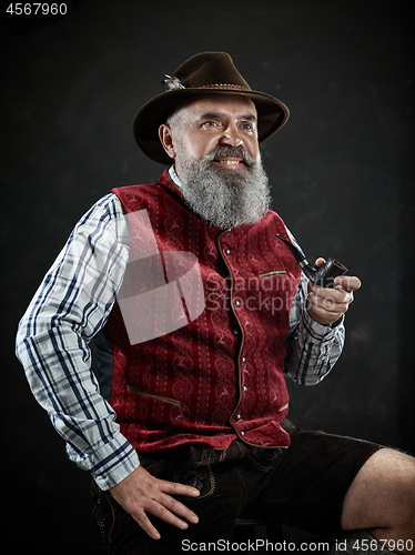 Image of dramatic portrait of senior smoking tobacco pipe