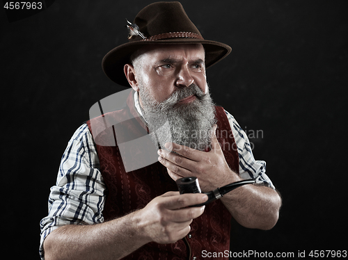 Image of dramatic portrait of senior smoking tobacco pipe