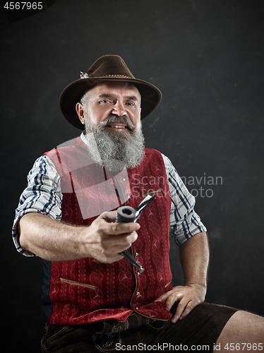 Image of dramatic portrait of senior smoking tobacco pipe