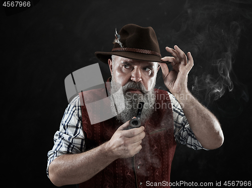 Image of dramatic portrait of senior smoking tobacco pipe