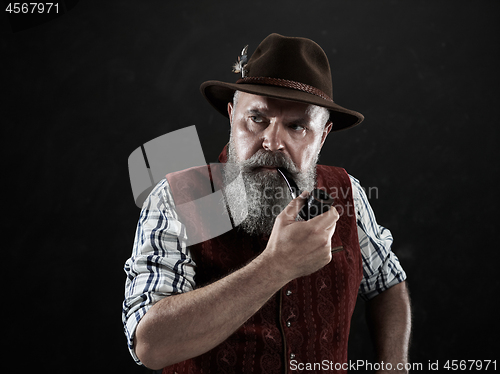 Image of dramatic portrait of senior smoking tobacco pipe