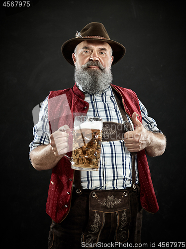 Image of Germany, Bavaria, Upper Bavaria, man with beer dressed in in traditional Austrian or Bavarian costume