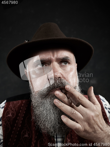 Image of dramatic portrait of senior smoking tobacco pipe