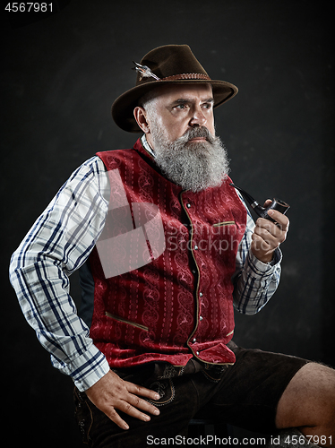 Image of dramatic portrait of senior smoking tobacco pipe