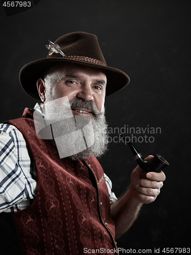 Image of dramatic portrait of senior smoking tobacco pipe