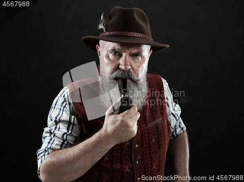 Image of dramatic portrait of senior smoking tobacco pipe