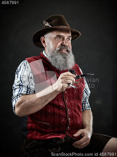 Image of dramatic portrait of senior smoking tobacco pipe