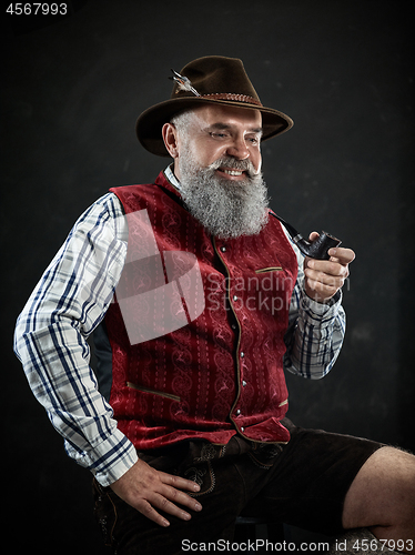 Image of dramatic portrait of senior smoking tobacco pipe