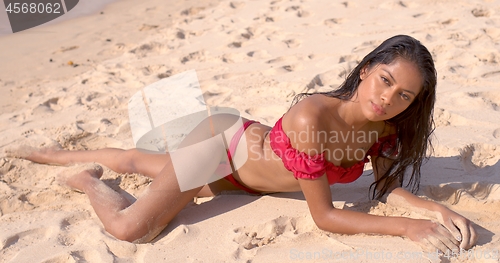 Image of Sensual woman lying on sandy beach