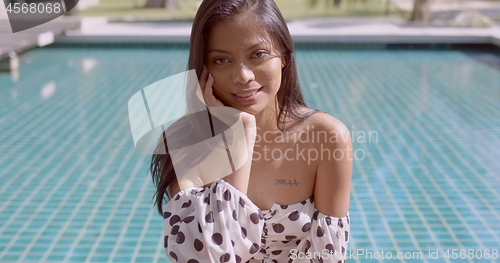 Image of Charming Asian young lady relaxing at poolside