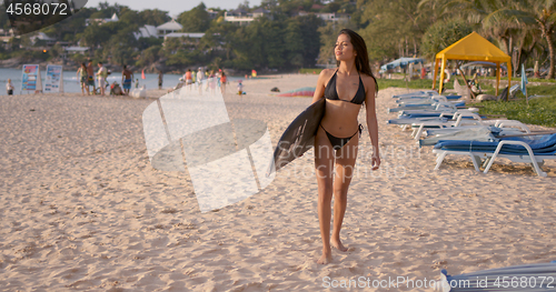 Image of Happy woman with surfboard walking on sandy beach