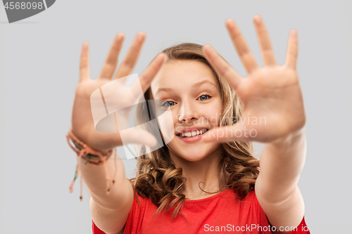 Image of happy teenage girl in red t-shirt giving high five