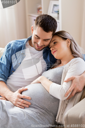 Image of man hugging pregnant woman at home