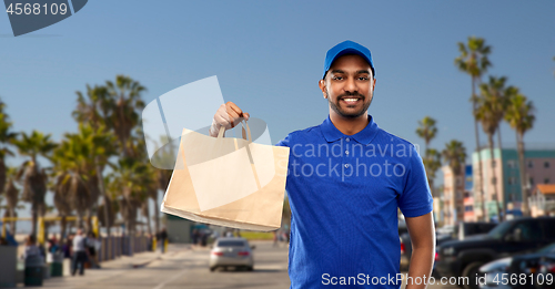 Image of happy indian delivery man with food in paper bag