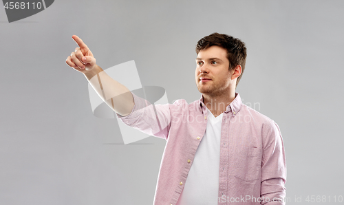 Image of young man showing something