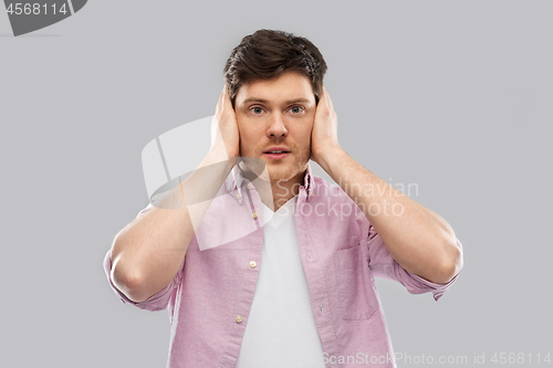 Image of man closing ears by hands