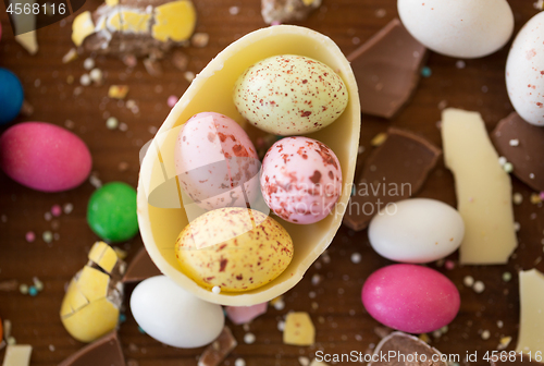 Image of chocolate egg and candy drops on wooden table