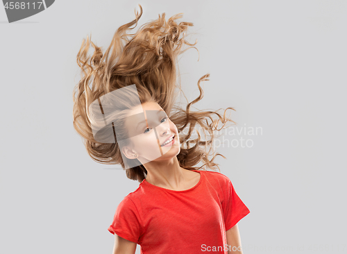 Image of smiling teenage girl in red with long wavy hair