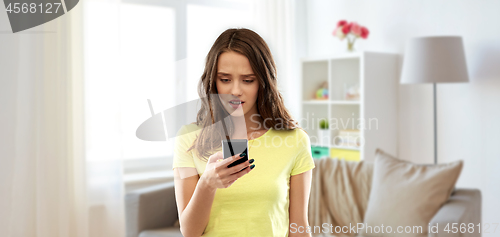 Image of young woman or teenage girl using smartphone