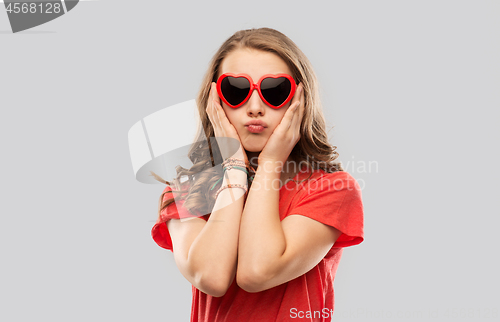 Image of girl in red heart shaped sunglasses pouting