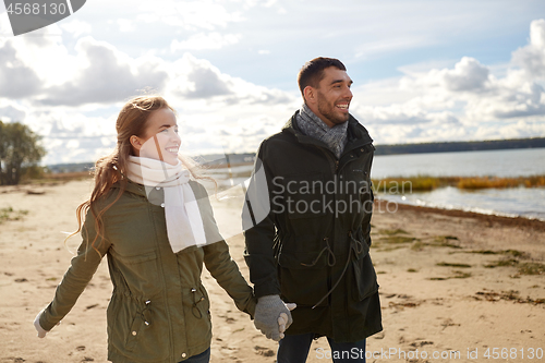 Image of couple walking along autumn beach