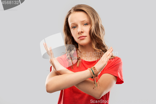 Image of teenage girl crossing hands in forbidding gesture