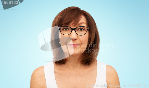 Image of portrait of senior woman in glasses over white