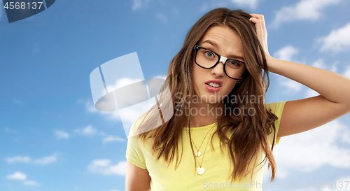 Image of confused young woman or teenage girl in glasses