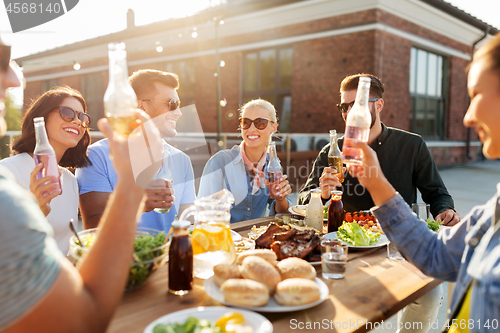 Image of happy friends with drinks or bbq party on rooftop