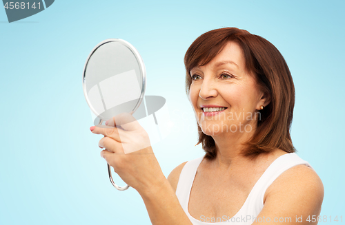 Image of portrait of smiling senior woman with mirror