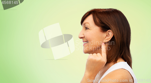 Image of smiling senior woman pointing to her earring