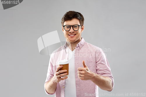 Image of man in glasses with coffee showing thumbs up