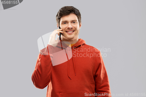 Image of young man in red hoodie calling on smartphone