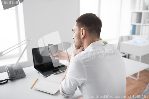 Image of businessman using smartphone at office