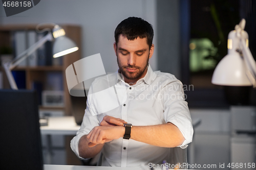 Image of happy businessman with smart watch at nigh office